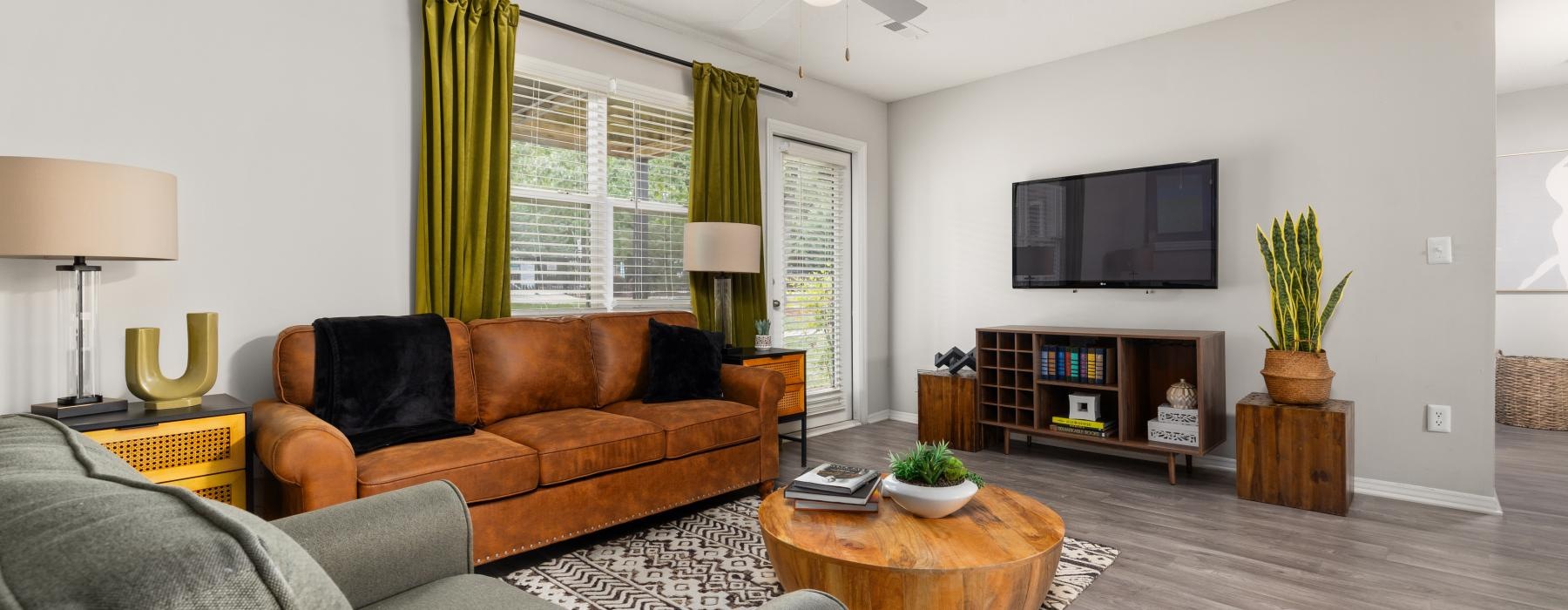 a living room with a wood floor couch and ottoman