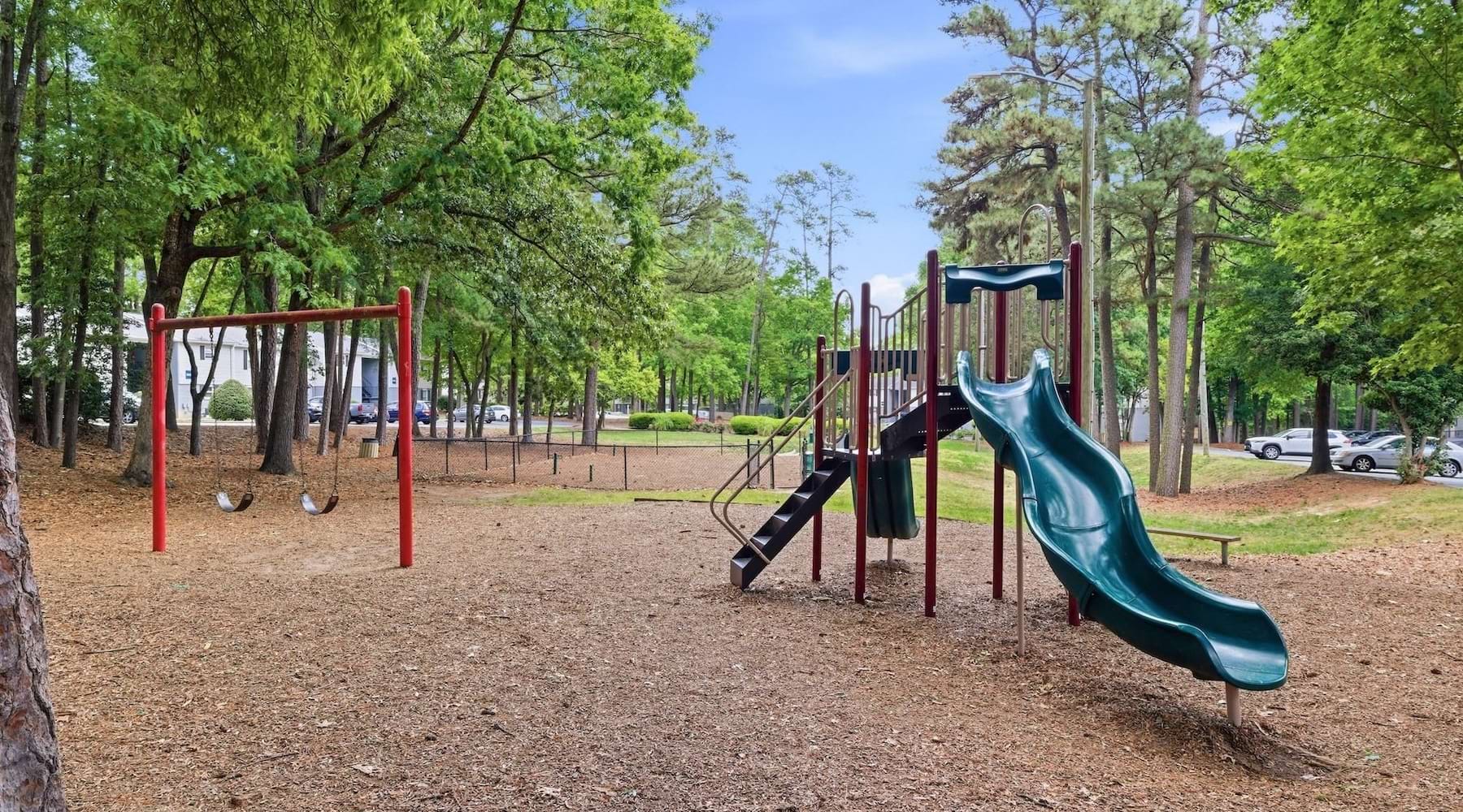 a playground with trees and a slide