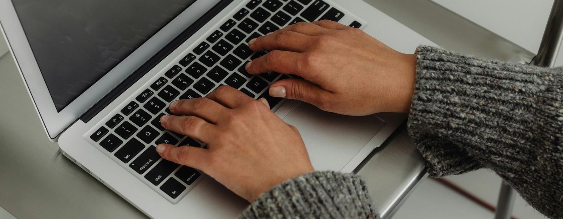 A person typing on a laptop.