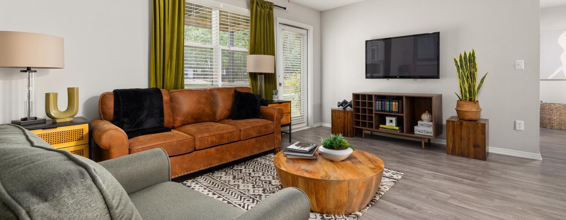 a living room with a wood floor couch and ottoman