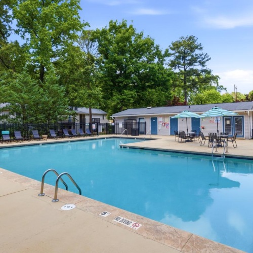 a swimming pool with trees and buildings around it